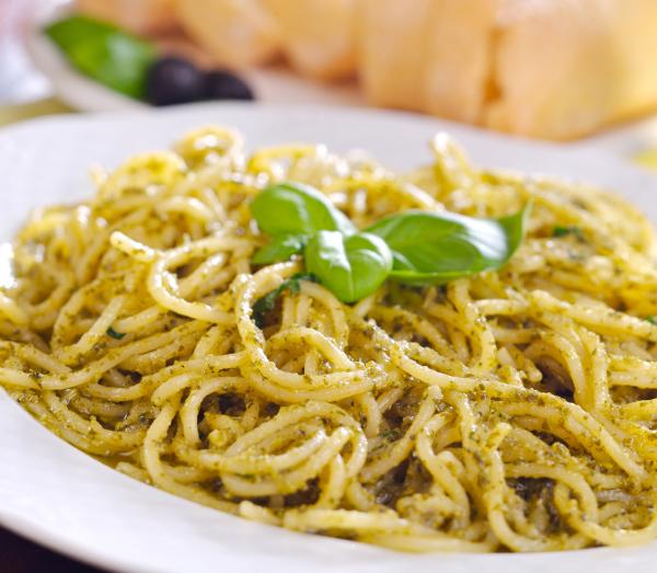 A plate of spaghetti with pesto sauce