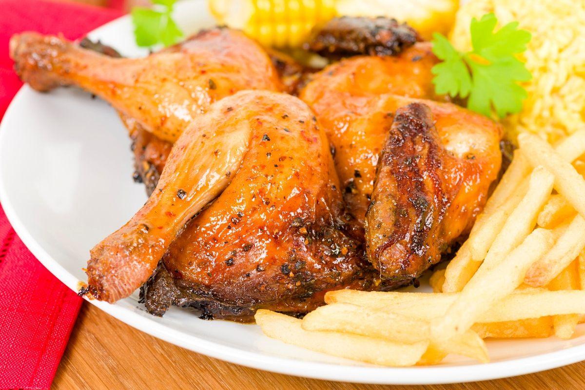 A piece of grilled chicken on a plate accompanied of fries.