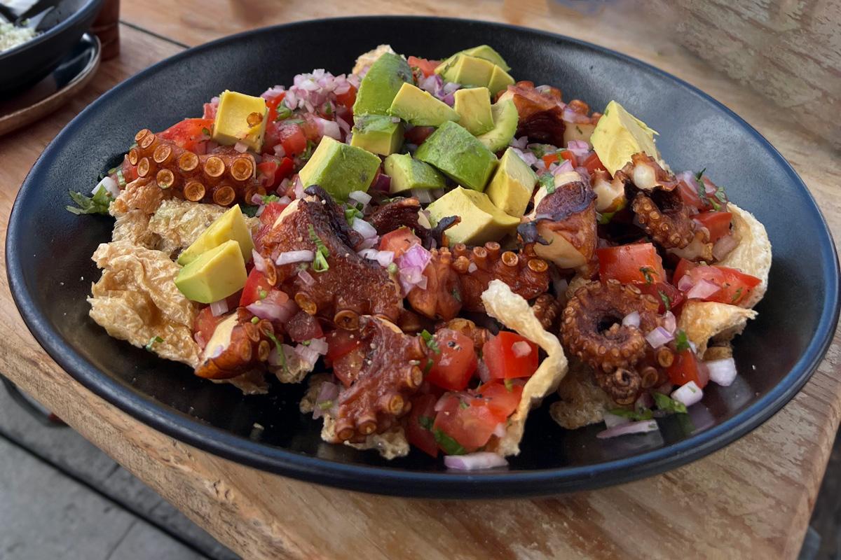 Crispy ocotups bites, chicharrón de pulpo, in  a plate on a wooden table. 