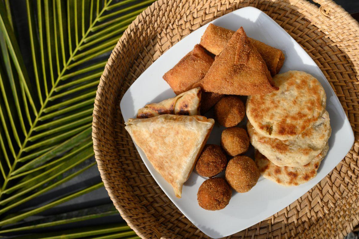 Authentic Sri Lankan street food, short eats like vegetable roti, coconut roti, cutlets and mutton rolls on white plate.