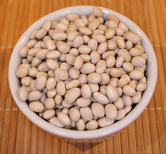 Dry haricot beans in a white container.