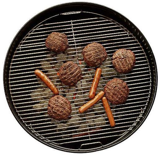 Meat and sausages cooking on a charcoal barbecue.