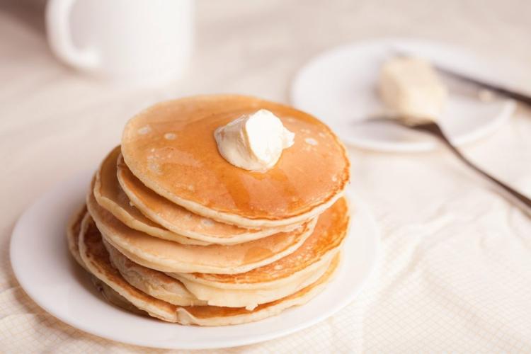 A pile of pancakes with butter.