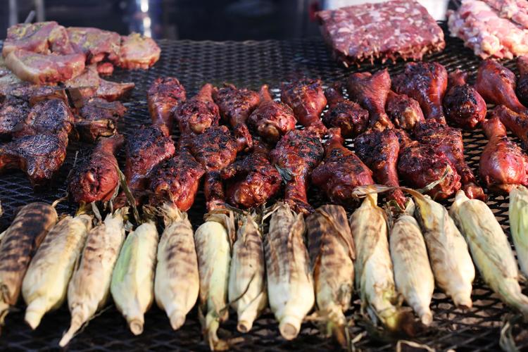Turkey legs and corn cooking over the grill at a Minnesota fair.