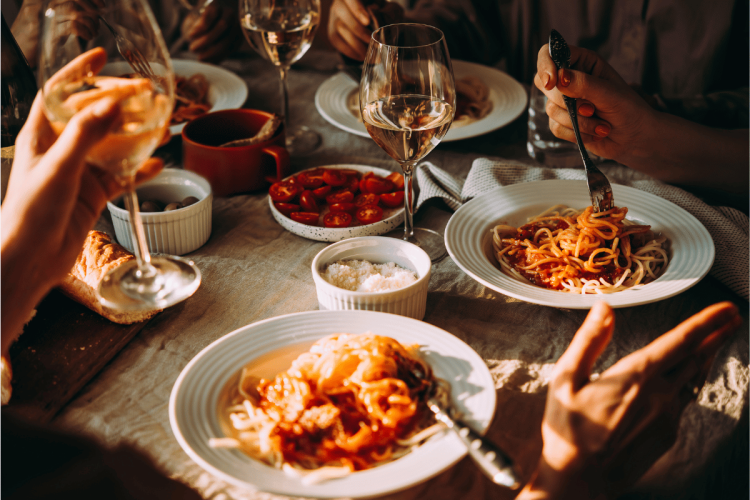 Friends having a pasta dinner with wine.