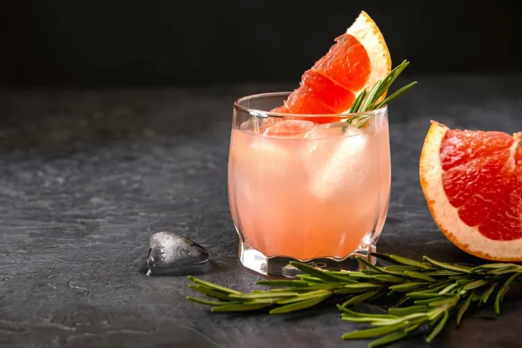 Pink grapefruit spritz with slice of pink grapefruit and rosemary.