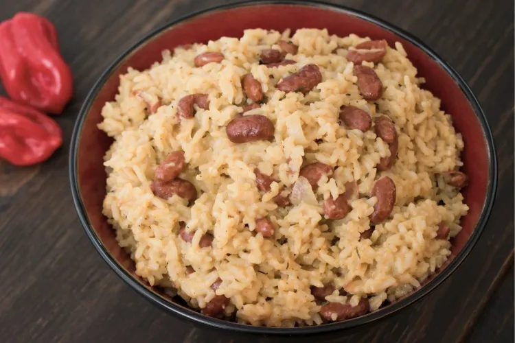 A erceipient with creamy rice and red beans, a traditional Caribbean dish.