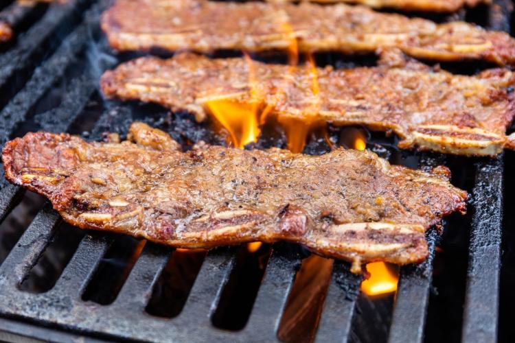 A few beef short ribs on the grill, the beefs have been cut and marinated Korean style.