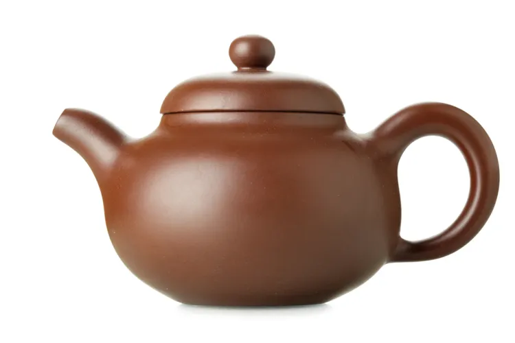 Traditional Yixing clay teapot with round body, curved spout, and lid.