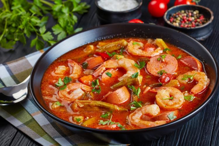 A deep black bowl with crab, shrimp, okra and sausage gumbo.