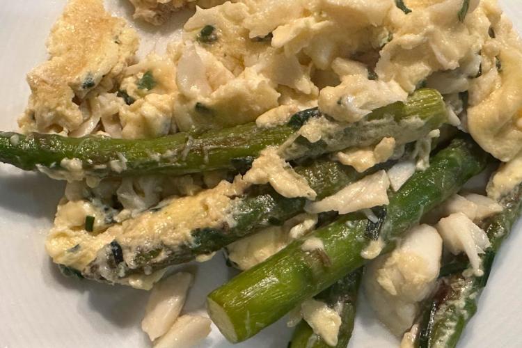 Scrambled eggs with asparagus, crab and chives in a plate.