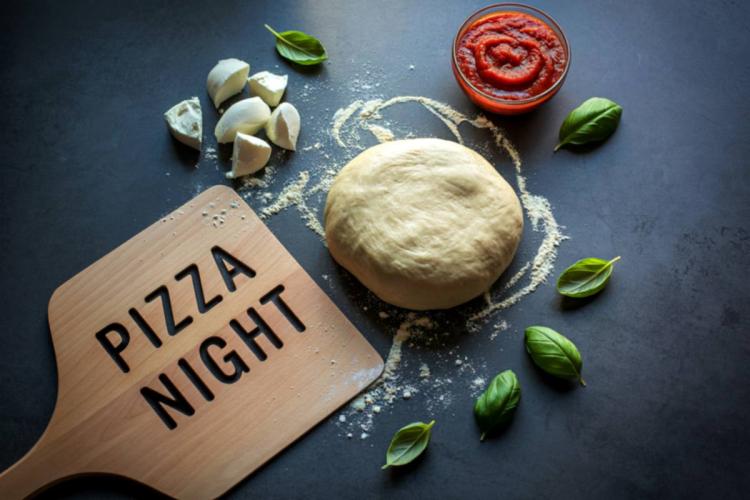 Ingredients and utensils to prepare homemade pizza on pizza night.