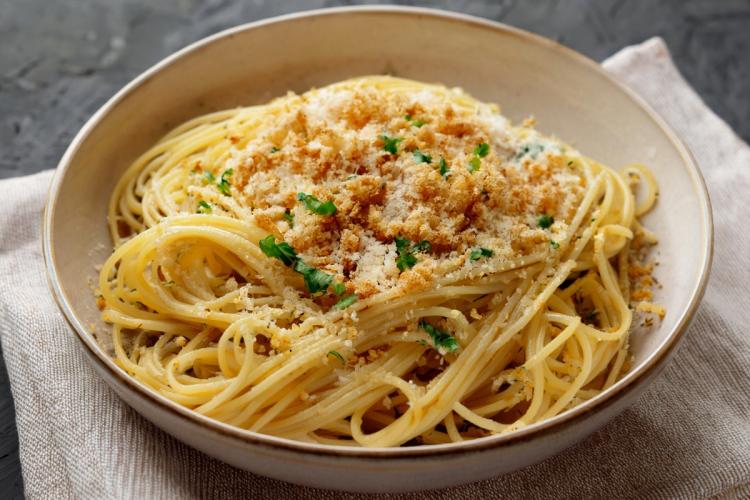 A large bowl with spaghetti aglio e olio with toasted breadcrumbs.