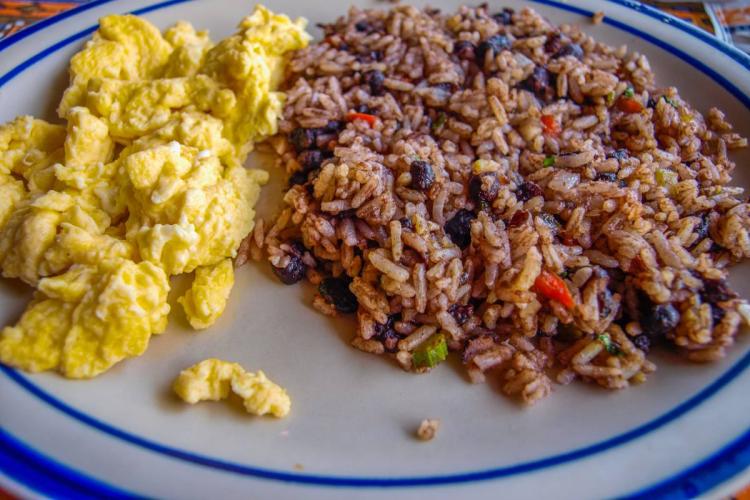 Costa Rican breakfast of gallo pinto with black beans and rice served with scrambled eggs.