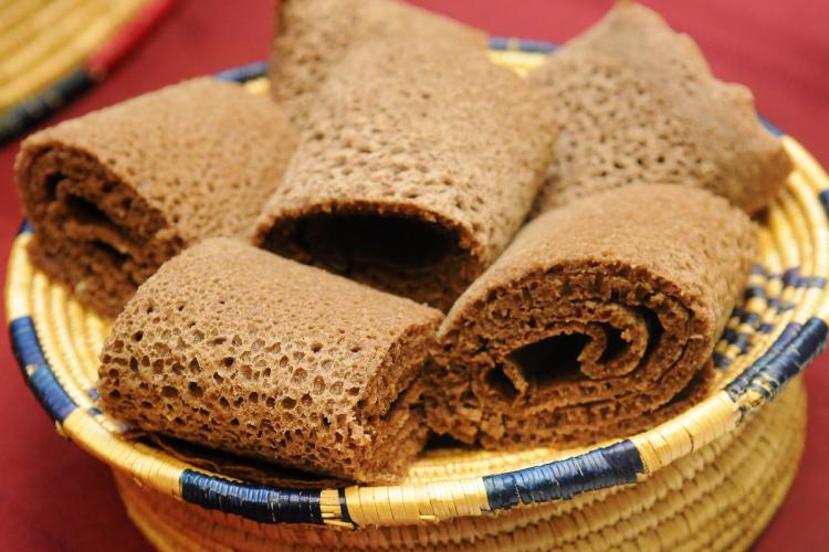 Rolls of Ethiopian injera arranged in a traditional woven basket.