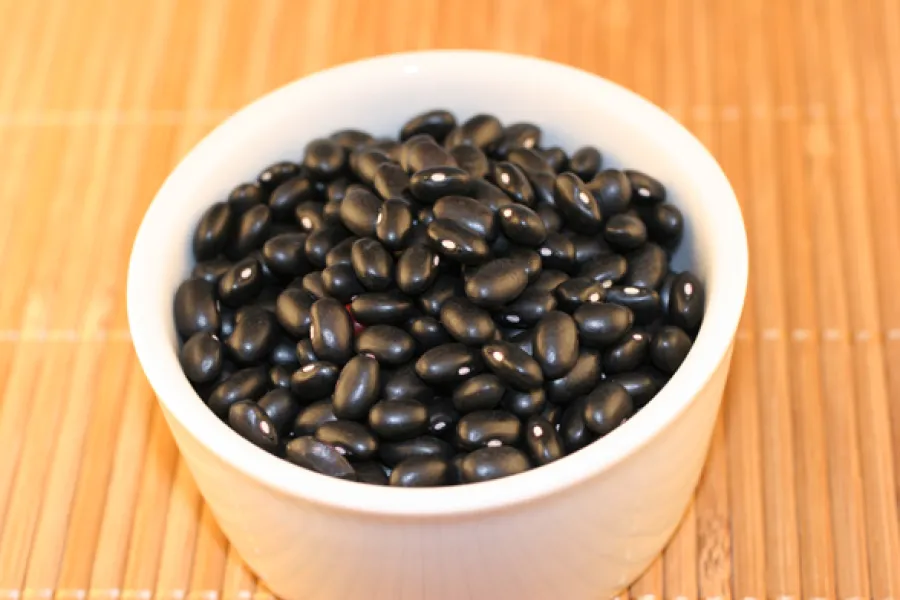 Black turtle beans in a white container.