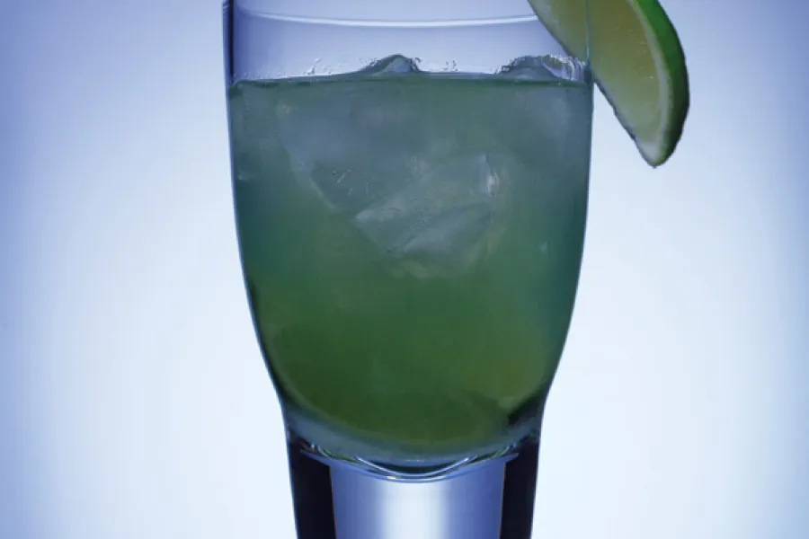 A glass with the drink surfer's paradise, a refreshing combination with lime.