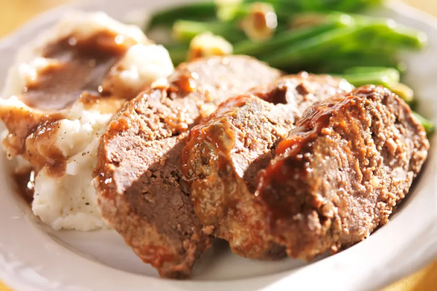 A piece of meatloaf and some meatloaf slices.