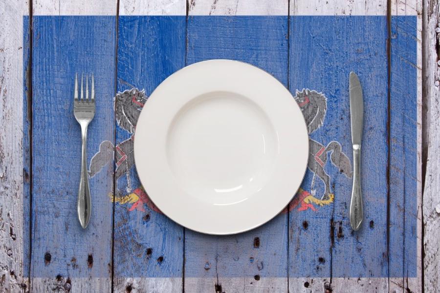 Concept food in Pennsylvania with a white dish and cutlery on a rustic table.