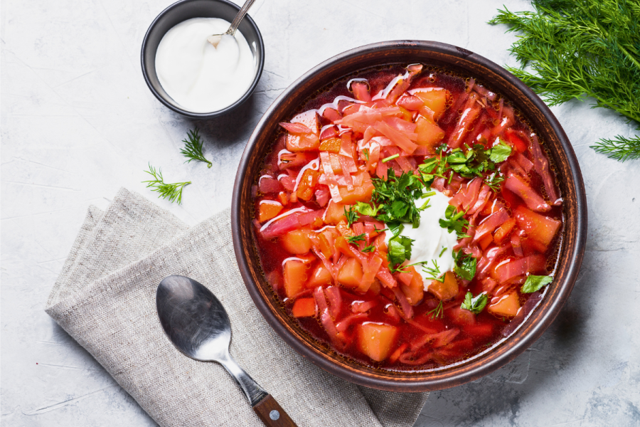 Traditional Ukranian borscht soup in a bowl on gray stone.