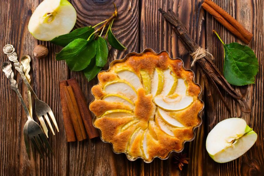 A freshly baked apple pie with a golden crust and apple slices arranged in a circular pattern on top. 