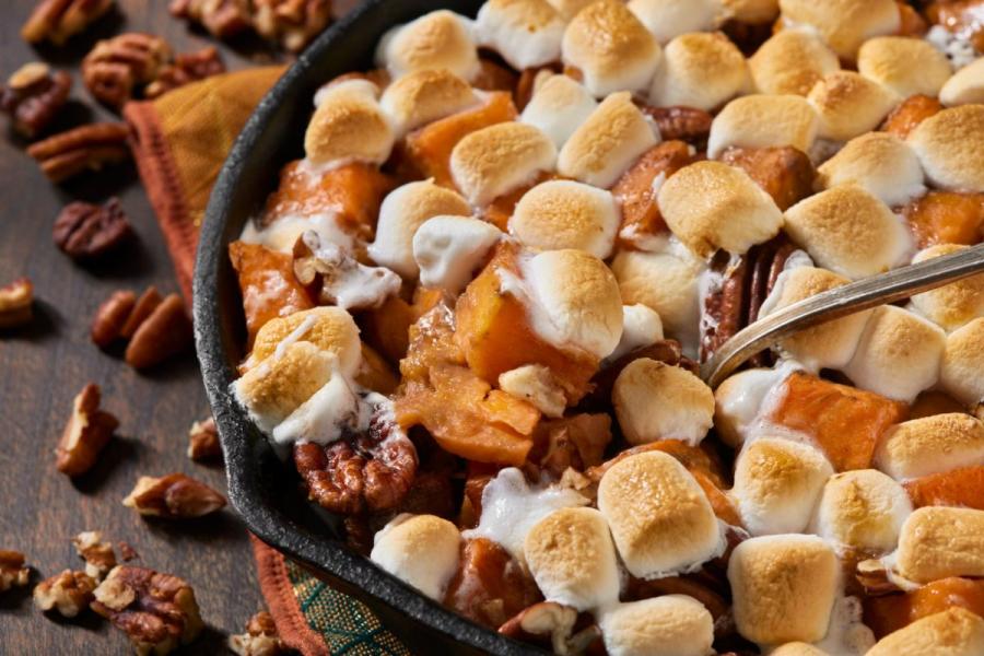 Top view of a sweet potato casserole with marshmallows and pecans.