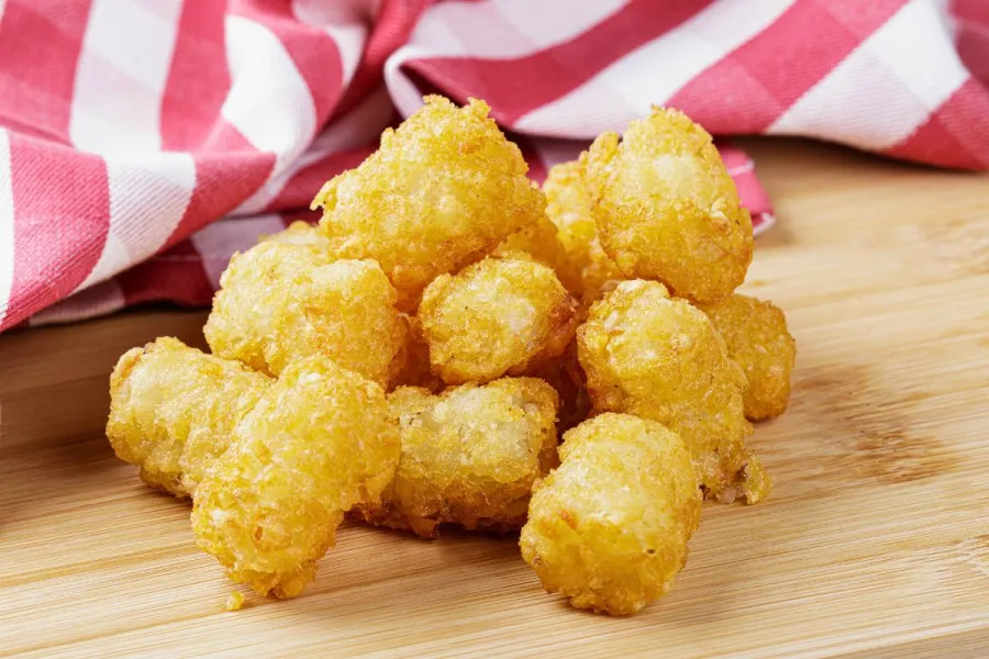 Tater tots on a wooden surface.
