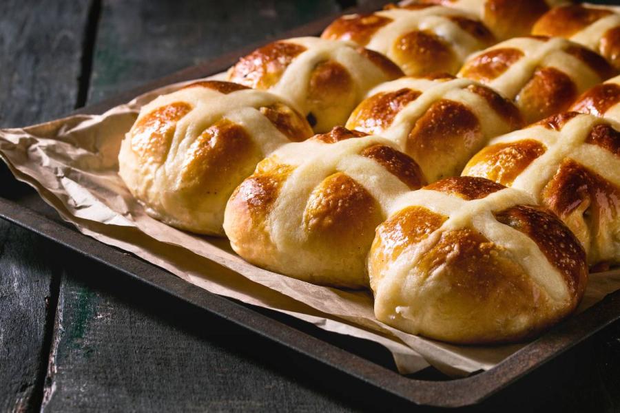 Homemade Easter traditional hot cross buns on oven tray with baking paper.