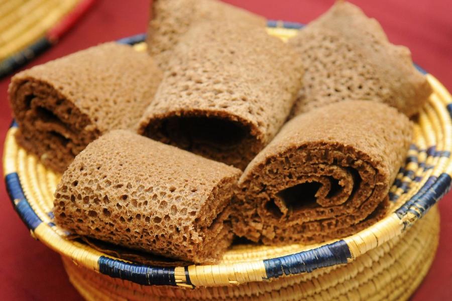 Rolls of Ethiopian injera arranged in a traditional woven basket.