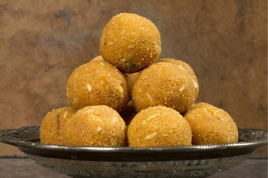 Besan ke laddos piled on a plate.