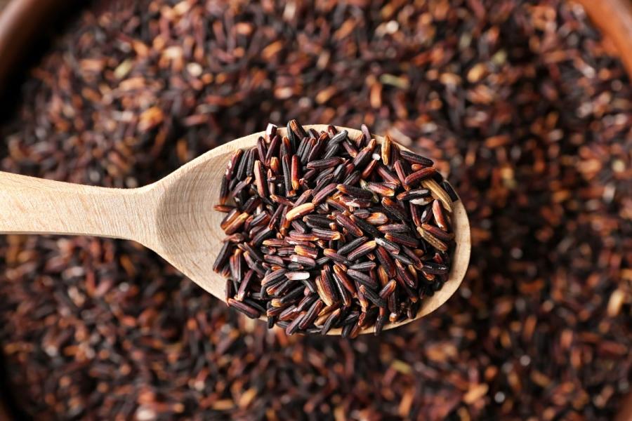 A wooden spoon with wild rice.