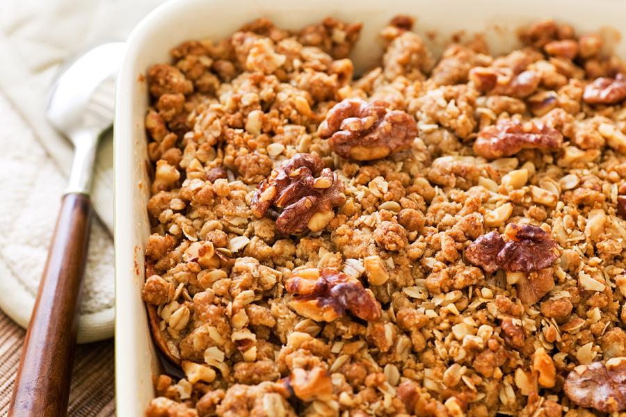 Homemade apple crisp with walnut toppin in an oven pan.