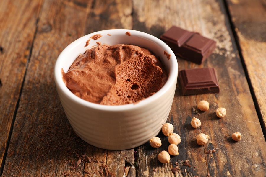 An individual container with vegan chocolate mousse, made with aquafaba.