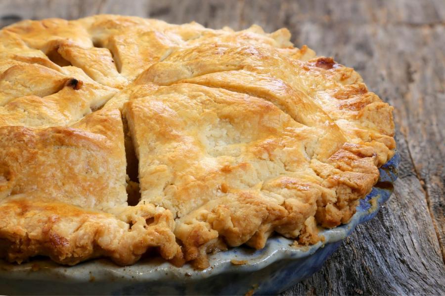 A scrumptious double-layered apple pie, featuring a golden-brown crust and a delicious apple filling.
